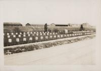 sepia toned image of the cemetery created after Carlisle closed, three rows of white square headstones occupy the middleground with a dirt road in the foreground and buildings in the far background