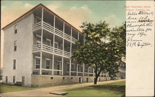 color image; view of the northwest corner of the large boys' quarters (three floors), a tree is in the foreground on the right side of the image