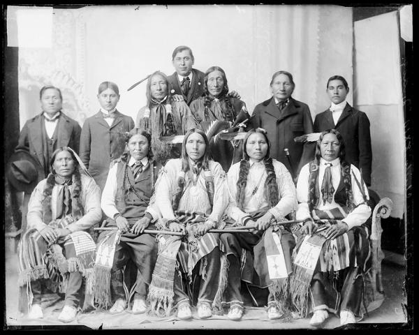 Seven visiting chiefs with two older Native American men and three male students, c.1890