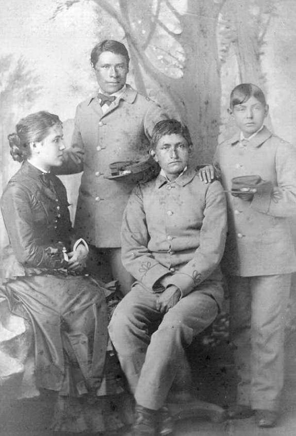 Three male Pueblo students with Miss Shields [version 2], c.1883