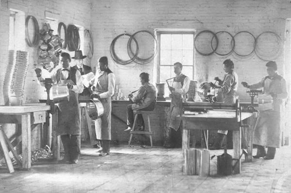 Male students posed in the tin shop with Richard Henry Pratt and instructor, c.1880