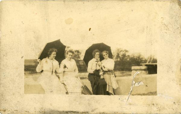 Four female teachers with umbrellas, c. 1910