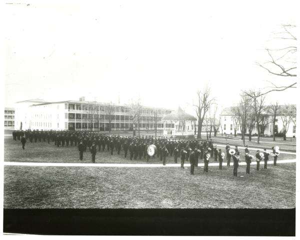 Male students in formation with band on school grounds, c. 1910