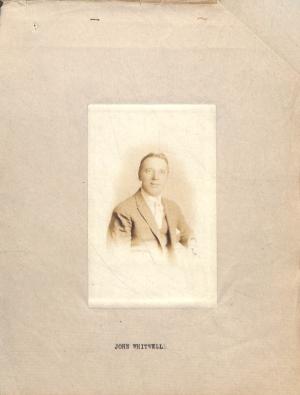 sepia toned photograph of a man, pictured from waist up, in suit, vest, and tie
