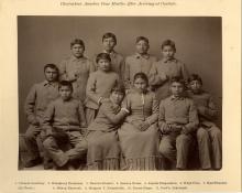 Studio portrait of eight male and three female students, all wearing school uniforms. 