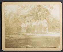 Eight female students posed on a bridge in the woods, c.1894