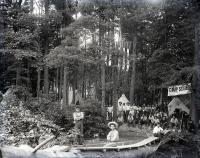 Male students sitting on a log bridge at Camp Sells, c. 1913