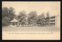 black and white image; band stand on the left and girls' quarters on the right, trees around both