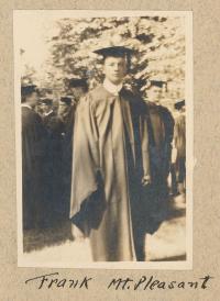 sepia toned photograph of man standing in cap and gown