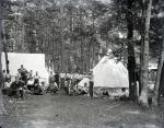 Male students posed watched a violin performance at Camp Sells, c. 1913