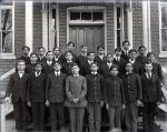 Large group of male students posed in front of a building, c. 1905