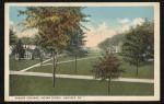 color image; view of campus looking northeast from the academic building, trees have been painted into the foreground and cover most of the buildings that would otherwise be visible (quarters, gymnasium, superintendent's quarters)