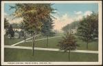 color image; view of campus looking northeast from the academic building, trees have been painted into the foreground and cover most of the buildings that would otherwise be visible (quarters, gymnasium, superintendent's quarters)