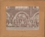United States Delegation to 1908 Olympics sepia toned photograph of 51 men sitting and standing in rows in front of ivy covered stonework